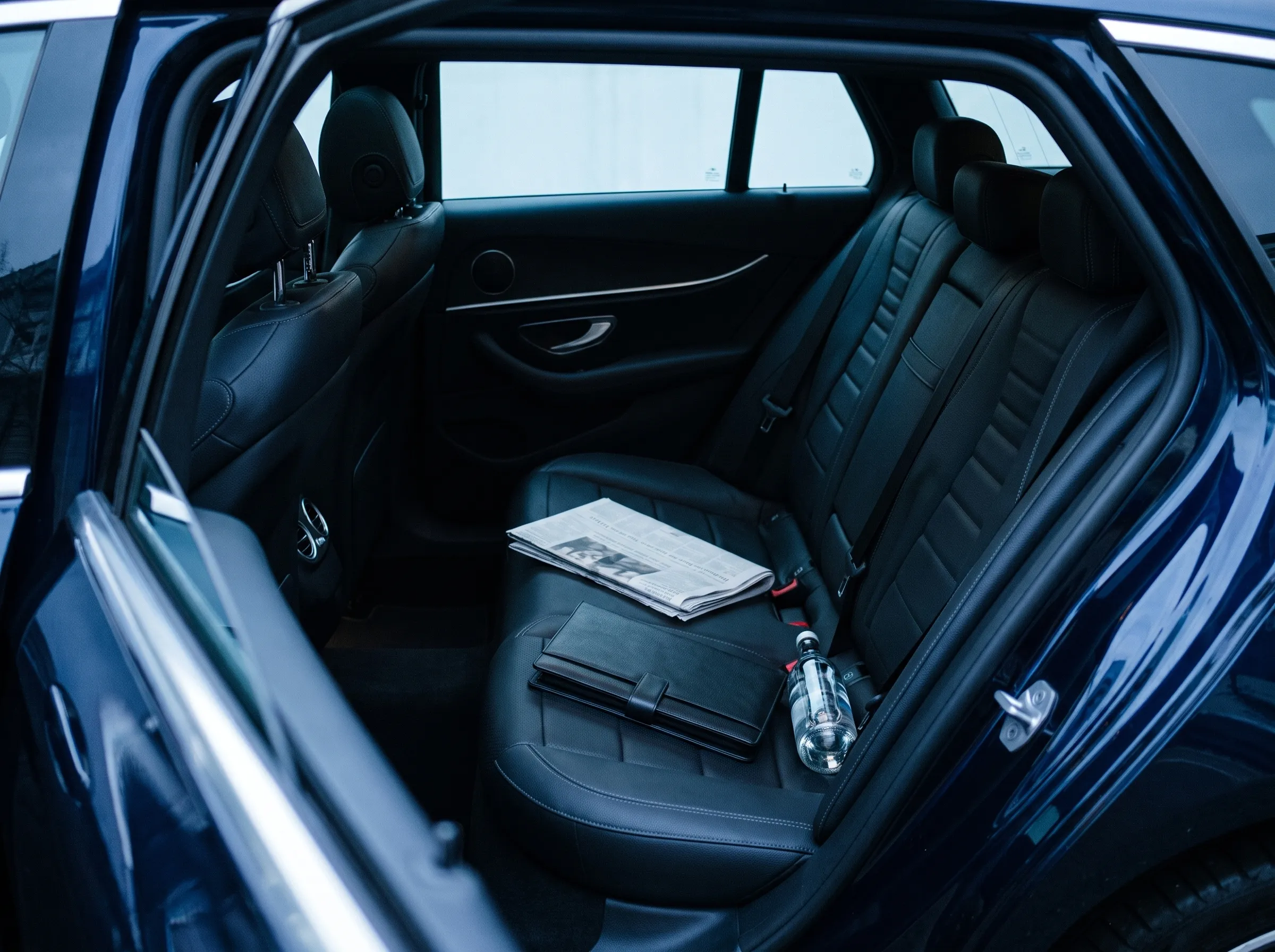 The rear cabin of the E-Class with a newspaper and water on the seat